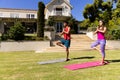 Happy diverse fit couple practicing yoga standing on one leg in sunny garden, copy space Royalty Free Stock Photo
