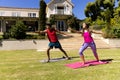 Happy diverse fit couple practicing yoga standing and stretching in sunny garden Royalty Free Stock Photo