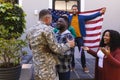 Happy diverse friends with flags welcoming home male soldier friend