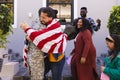 Happy diverse friends with flags welcoming home male soldier friend