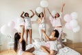 Happy diverse girls playing with balloons in bedroom at party Royalty Free Stock Photo