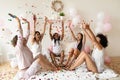 Happy diverse girls sitting on bed in circle, throwing confetti Royalty Free Stock Photo