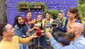 Happy diverse group of friends celebrating new year eve making a celebratory toast clinking beautiful gourmet cocktail glasses in Royalty Free Stock Photo