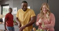 Happy diverse group of friends preapring meal in kitchen, slow motion