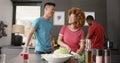 Happy diverse group of friends preapring meal in kitchen, slow motion