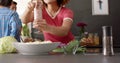 Happy diverse group of friends preapring meal in kitchen, slow motion