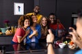 Happy diverse group of friends taking photo with smartphone in kitchen Royalty Free Stock Photo