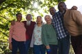 Happy diverse group of senior friends embracing and smiling in sunny garden Royalty Free Stock Photo