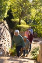 Happy diverse group of senior friends walking up stairs in sunny garden Royalty Free Stock Photo