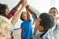 Happy diverse kids school students group giving high five together in classroom. Royalty Free Stock Photo