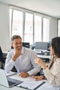 Happy diverse professional workers working in office with laptop, vertical. Royalty Free Stock Photo