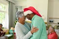 Happy diverse senior couple dancing in front of their diverse friends at christmas time Royalty Free Stock Photo