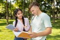 Happy diverse students studying with books, preparing for classes while walking in university campus outdoors Royalty Free Stock Photo