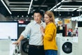 Happy diverse young family man and woman choose electronic household appliances Royalty Free Stock Photo