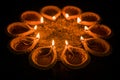 Happy Diwali and circle of Diya - many Terracotta diyas or oil lamps arranged over clay surface or ground in round or circular sha Royalty Free Stock Photo
