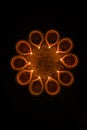 Happy Diwali and circle of Diya - many Terracotta diyas or oil lamps arranged over clay surface or ground in round or circular sha