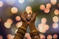 Happy Diwali - Woman hands with henna holding lit candle isolated on dark background. Clay Diya lamps lit during Diwali, Hindu Royalty Free Stock Photo