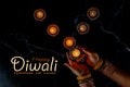 Happy Diwali - Woman hands with henna holding lit candle isolated on dark background Royalty Free Stock Photo