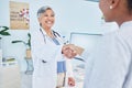 Happy doctor, handshake and meeting patient in healthcare, visit or appointment at the hospital. Mature female person or Royalty Free Stock Photo