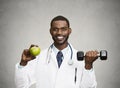 Happy doctor holding green apple, dumbbell Royalty Free Stock Photo