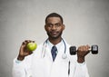 Happy doctor holding green apple, dumbbell Royalty Free Stock Photo