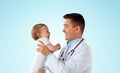 Happy doctor or pediatrician with baby over blue Royalty Free Stock Photo