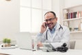 Happy doctor talking on phone with his patient Royalty Free Stock Photo