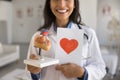 Happy doctor woman holding paper card with drawn heart