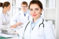 Happy doctor woman with medical staff at the hospital sitting at the table