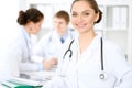 Happy doctor woman with medical staff at the hospital sitting at the table Royalty Free Stock Photo