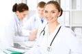 Happy doctor woman with medical staff at the hospital sitting at the table