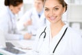 Happy doctor woman with medical staff at the hospital sitting at the table Royalty Free Stock Photo