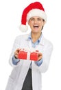 Happy doctor woman in santa hat giving christmas present box
