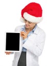 Happy doctor woman in santa hat showing tablet pc blank screen Royalty Free Stock Photo