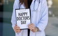Happy Doctors Day text with document brown envelope and stethoscope isolated on office desk Royalty Free Stock Photo