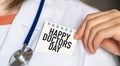 Happy Doctors Day text on white card in hand doctor taking it out of his pocket