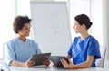 Happy doctors with tablet pc meeting at hospital Royalty Free Stock Photo