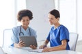 Happy doctors with tablet pc meeting at hospital