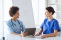 Happy doctors with tablet pc meeting at hospital Royalty Free Stock Photo