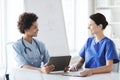 Happy doctors with tablet pc meeting at hospital Royalty Free Stock Photo