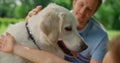 Happy dog enjoy caressing on picnic close up. Smiling man fondle white pet.