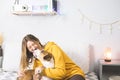 Happy dog licks woman`s face, indoor bedroom scene.