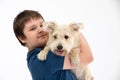 Young boy holds his dog in his arms. Subject isolated from the background.