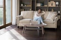 Happy dreamy Latin girl relaxing on home couch Royalty Free Stock Photo