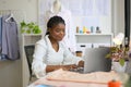 Happy dressmaker designer working in workshop studio