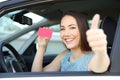 Happy driver showing card or license with thumbs up