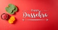 Happy Dussehra. Yellow flowers, green leaf and rice on red background. Dussehra Indian Festival concept