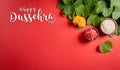 Happy Dussehra. Yellow flowers, green leaf and rice on red background. Dussehra Indian Festival concept