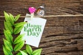 Happy Earth Day paper note hanging by red heart clips on wooden