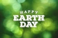 Happy Earth Day Rustic Text with Green Environmental Blurred Tree Leaf Bokeh Background